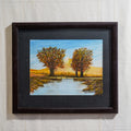 Pintura de paisaje de puente frente a dos árboles y montaña sobre río